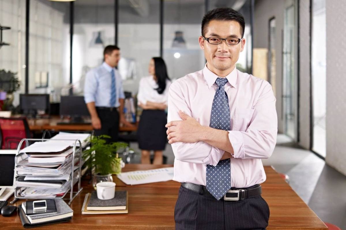 A man standing in front of some papers on a desk