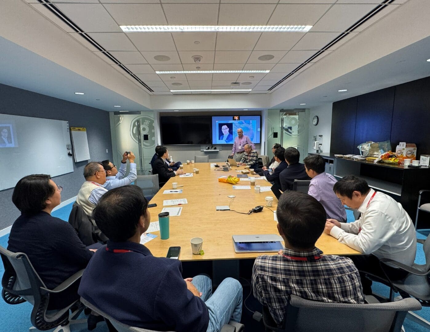 Team meeting around table with video presentation