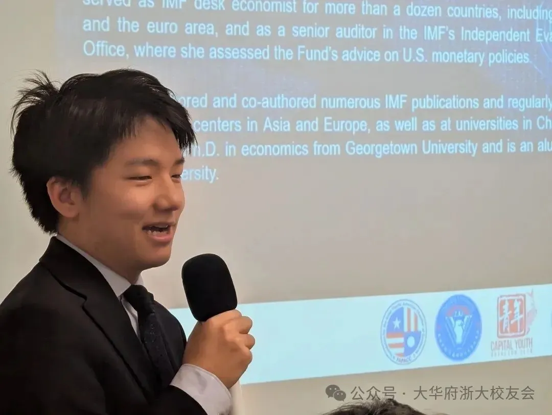 Man in suit speaking into microphone at presentation